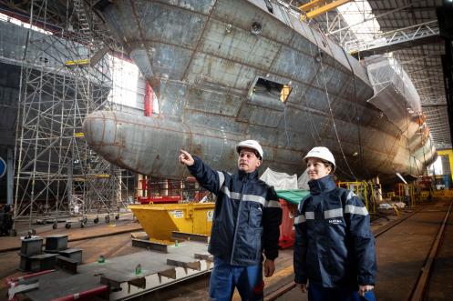 Ouvriers devant une coque de bateau à Lorient